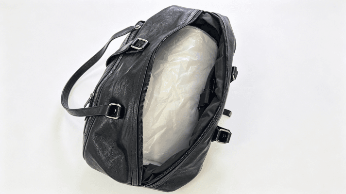 Inside view of duffle bag showing greyboard liner, greyboard sheet for bag shape retention