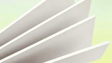A close-up of solid bleached board (SBS paperboard) showing its smooth white surface and paper edge thickness