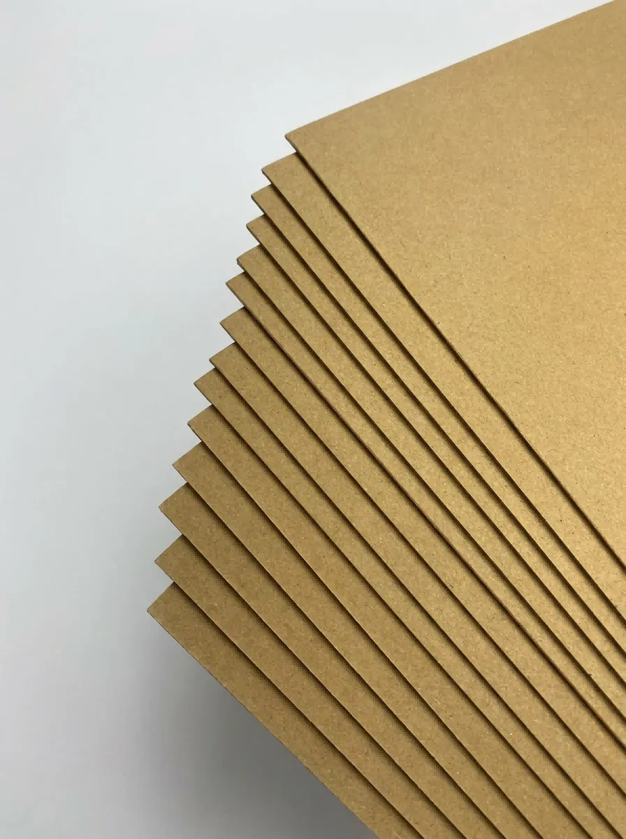 牛卡纸4 Brown kraft paper sheets stacked in warehouse for packaging, wrapping, and paper bag production