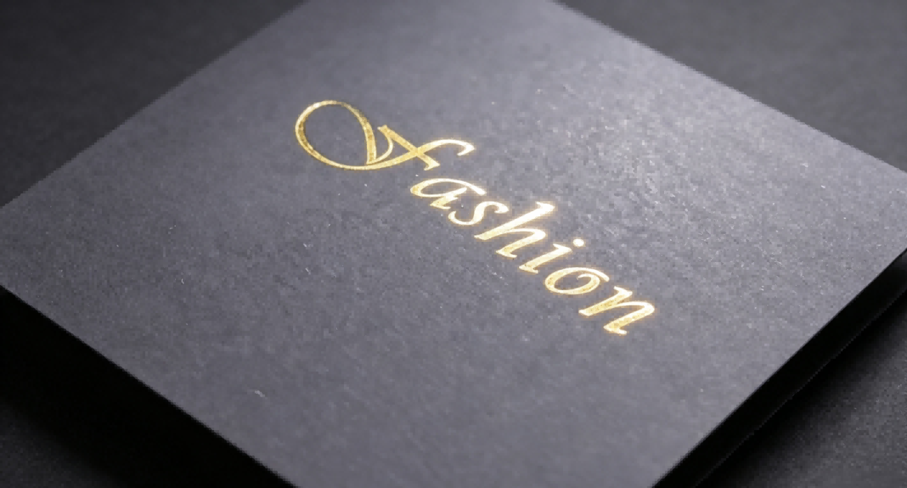 Gold hot foil stamping on solid black paperboard, luxury packaging material sample
